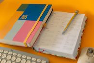 Vibrant 2025 planner and calendar on a desk setup for organization and planning.